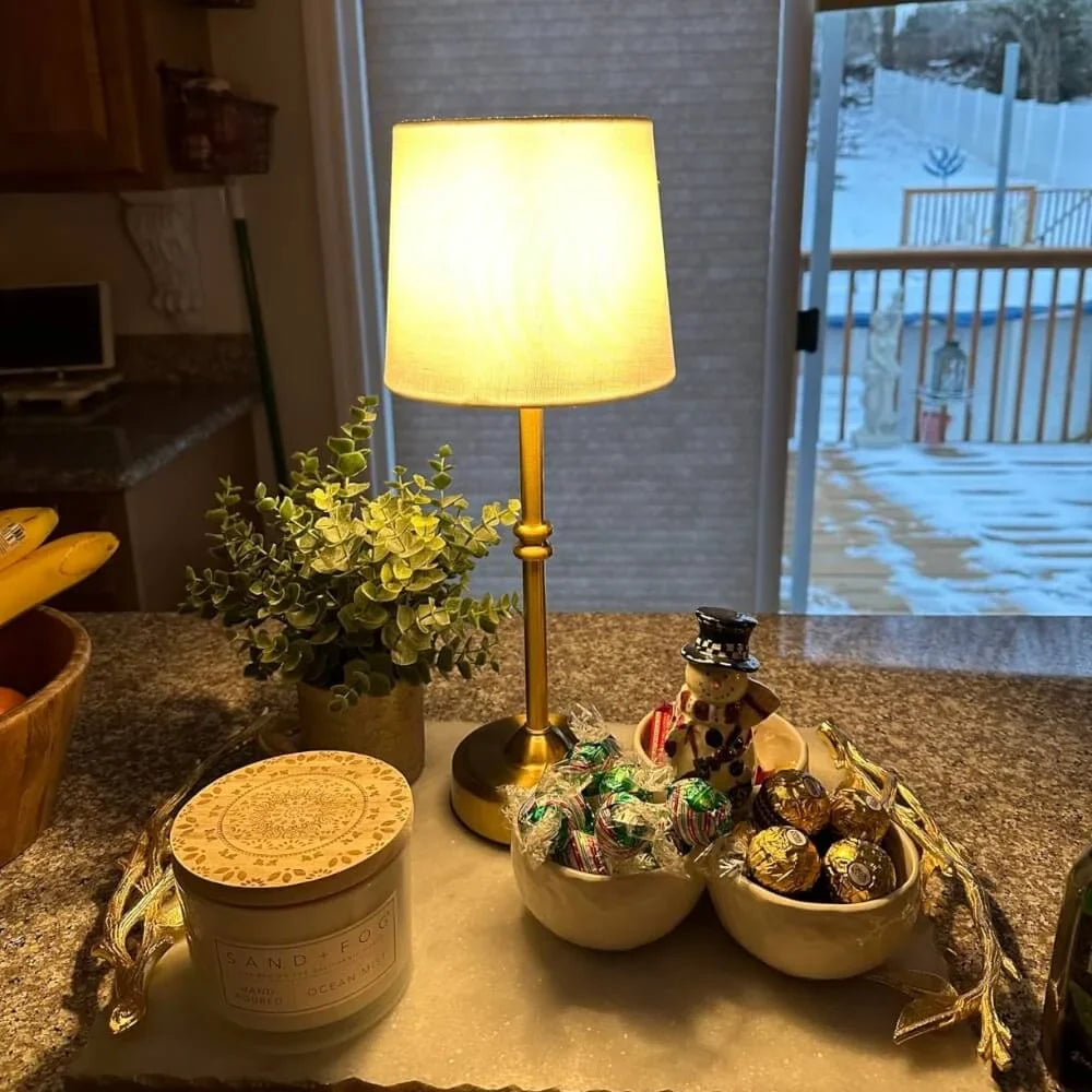Cordless LED table lamp with fabric shade on a shelf in an apartment