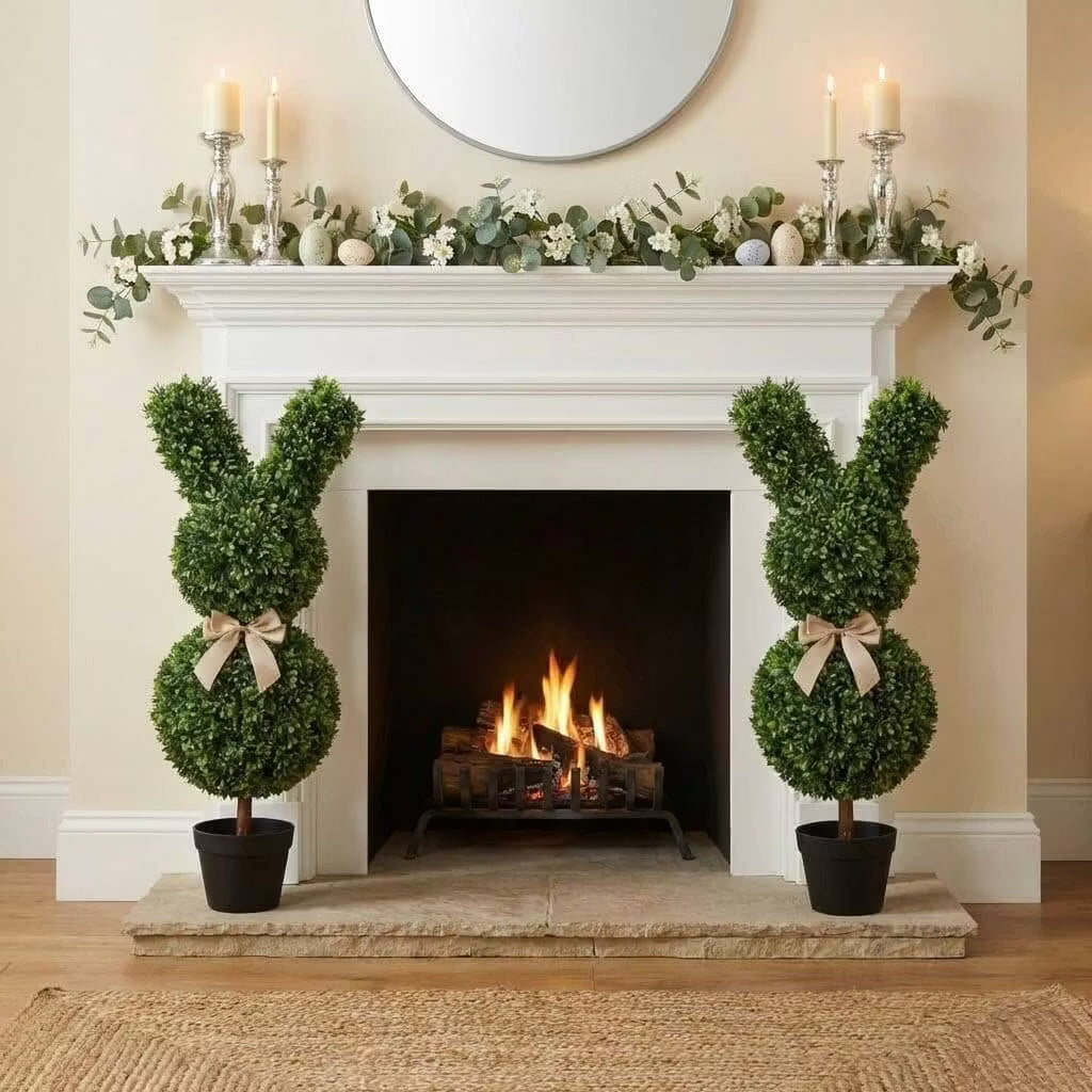 Set of two 36-inch artificial Easter bunny topiaries with green foliage and champagne bows on a porch
