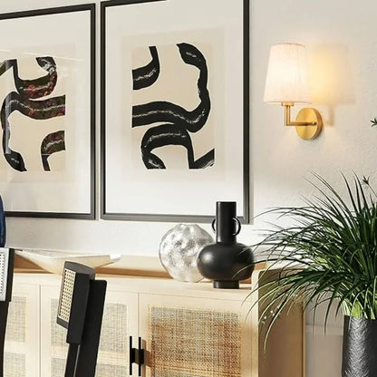 Wireless fabric wall sconce with metal accents, mounted on a wall, for renters