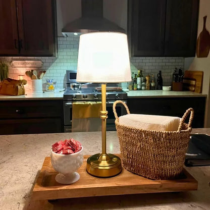 Cordless LED table lamp with fabric shade on a shelf in an apartment