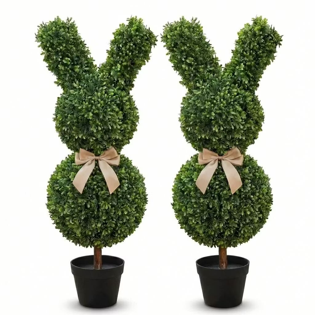 Set of two 36-inch artificial Easter bunny topiaries with green foliage and champagne bows on a porch