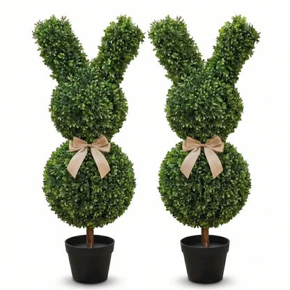 Set of two 36-inch artificial Easter bunny topiaries with green foliage and champagne bows on a porch