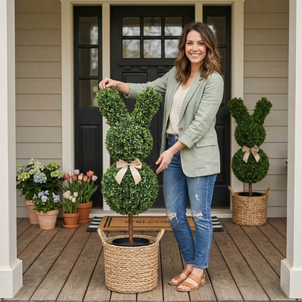 Set of two 36-inch artificial Easter bunny topiaries with green foliage and champagne bows on a porch