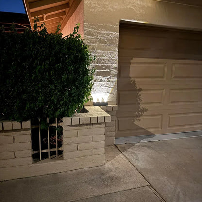 Black aluminum solar up down wall light mounted on exterior wall, no wires visible