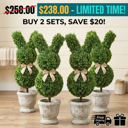 Set of two 36-inch artificial Easter bunny topiaries with green foliage and champagne bows on a porch