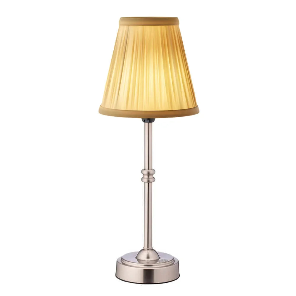 Cordless LED table lamp with fabric shade on a shelf in an apartment