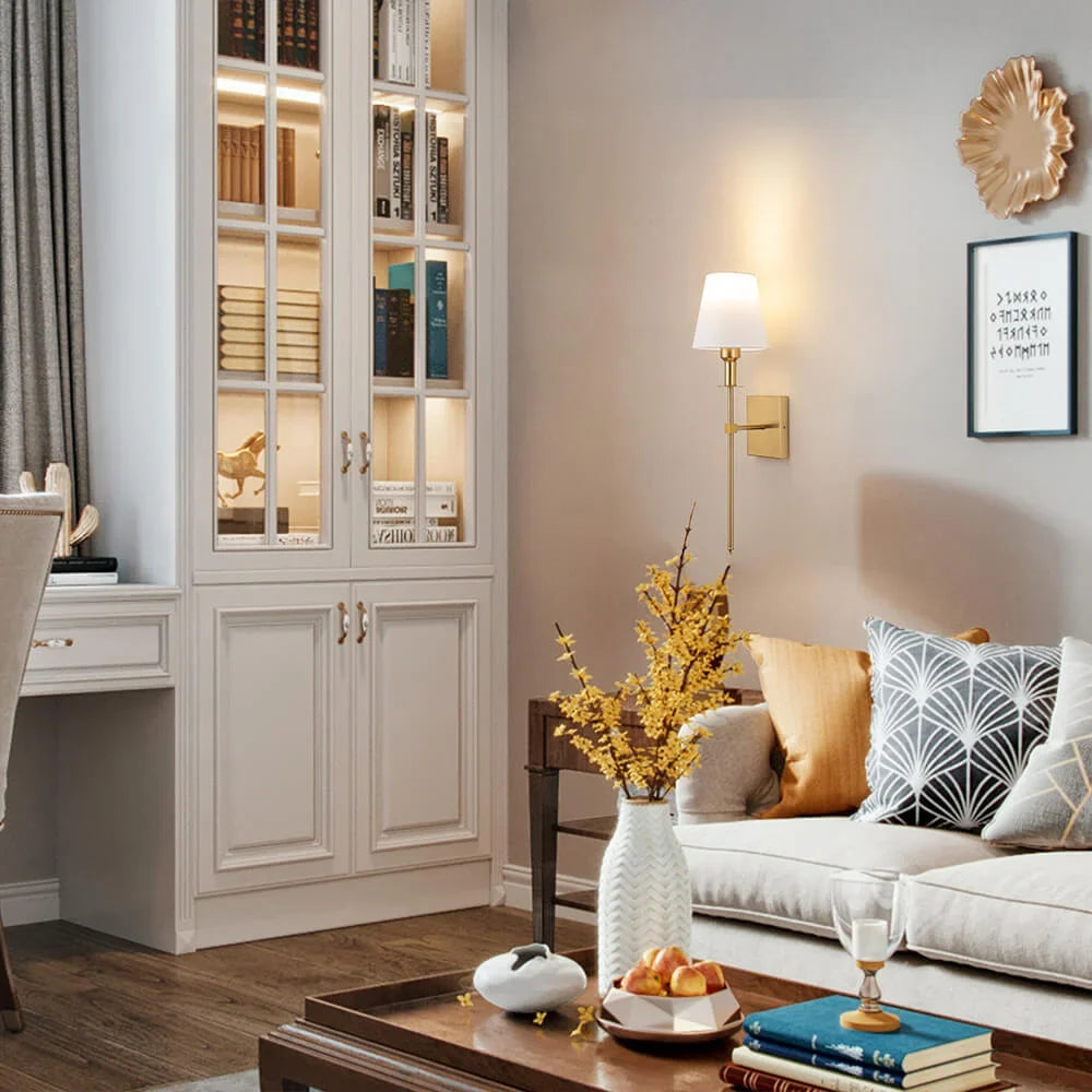 Rechargeable wireless wall light with metal accents, mounted on a wall in a living room, for renters