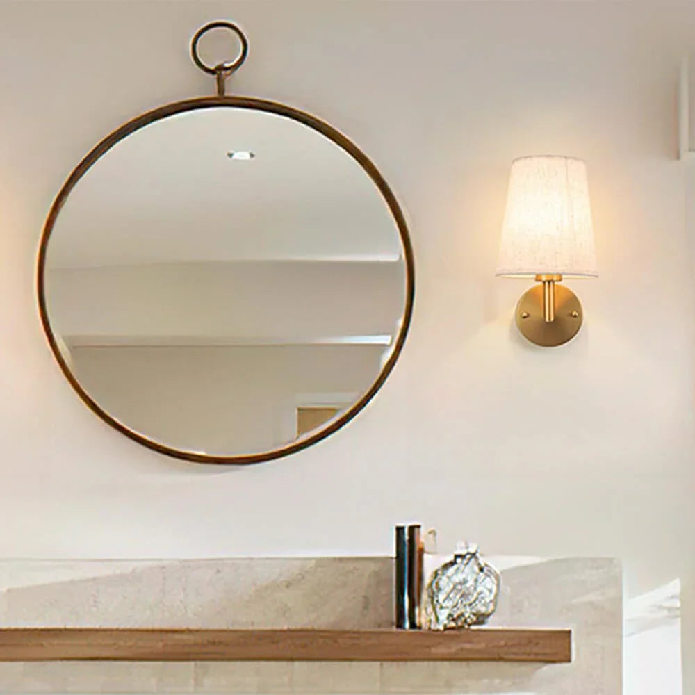 Wireless fabric wall sconce with metal accents, mounted on a wall, for renters