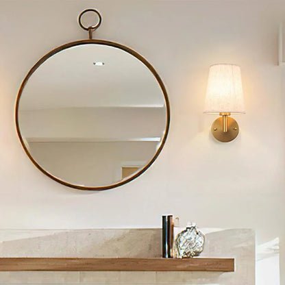 Wireless fabric wall sconce with metal accents, mounted on a wall, for renters