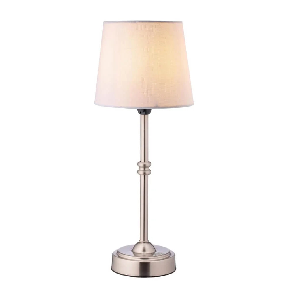 Cordless LED table lamp with fabric shade on a shelf in an apartment