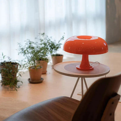 Mushroom-shaped acrylic table lamp with a warm glow on a bedside table
