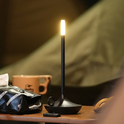 Rechargeable portable LED candle lamp with warm amber glow on a table, suitable for indoor and outdoor ambiance