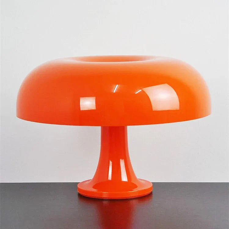 Mushroom-shaped acrylic table lamp with a warm glow on a bedside table