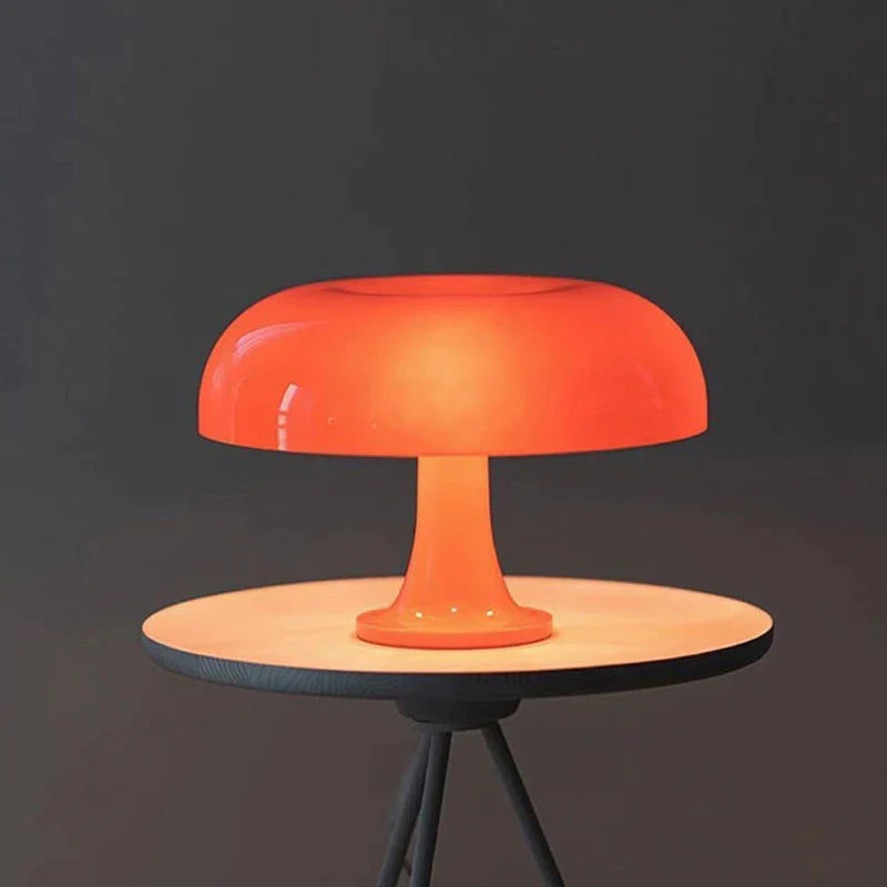 Mushroom-shaped acrylic table lamp with a warm glow on a bedside table