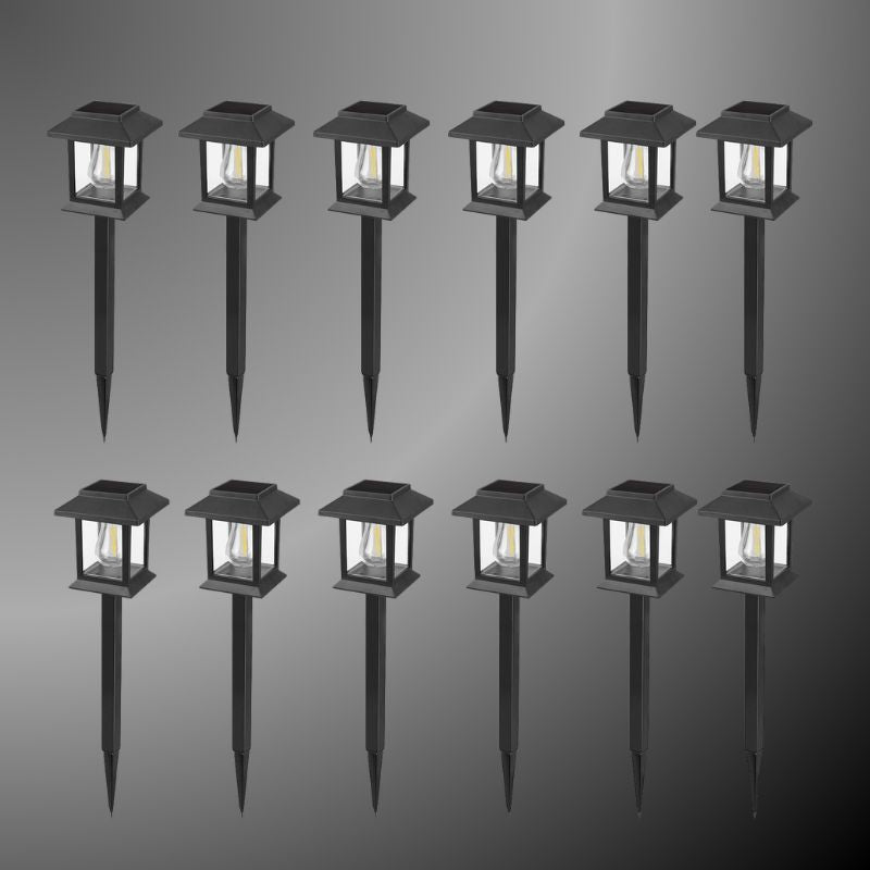 Edison-style solar lawn lights glowing along a garden path at dusk