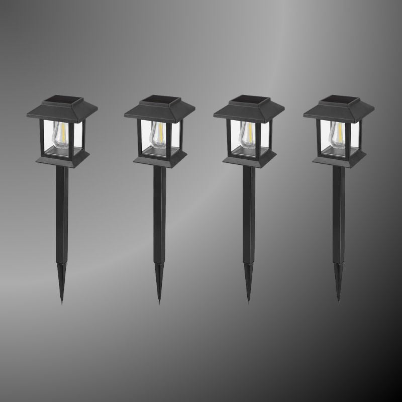Edison-style solar lawn lights glowing along a garden path at dusk