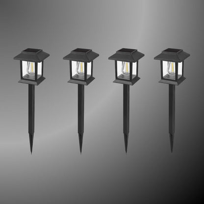 Edison-style solar lawn lights glowing along a garden path at dusk