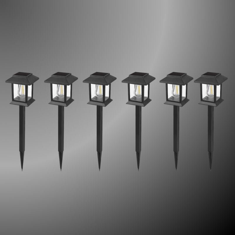 Edison-style solar lawn lights glowing along a garden path at dusk