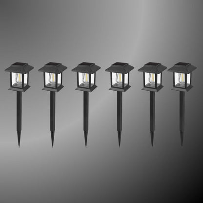Edison-style solar lawn lights glowing along a garden path at dusk