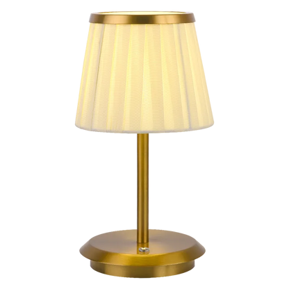 Cordless rechargeable table lamp with gold frame and fabric shade on a desk