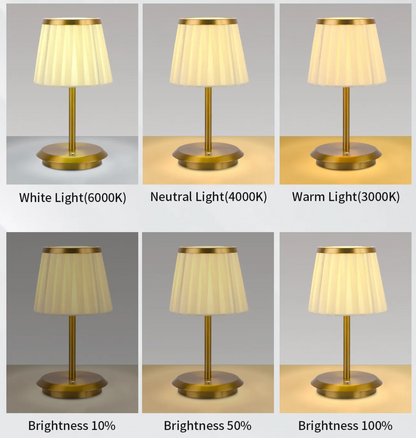 Cordless rechargeable table lamp with gold frame and fabric shade on a desk