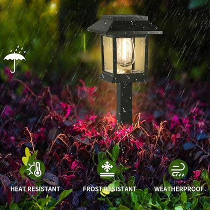 Edison-style solar lawn lights glowing along a garden path at dusk