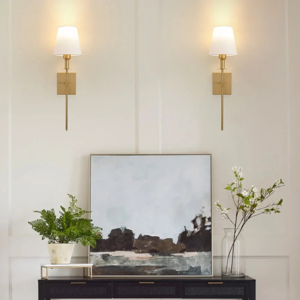 Rechargeable wireless wall sconce with metal and cloth shade, mounted on a wall in a living room, no cords visible