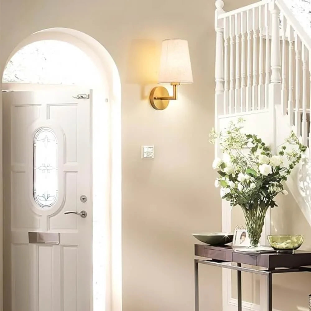 Wireless fabric wall sconce with metal accents, mounted on a wall, for renters