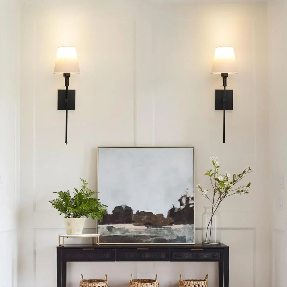 Rechargeable wireless wall light with metal accents, mounted on a wall in a living room, for renters