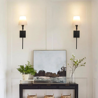 Rechargeable wireless wall light with metal accents, mounted on a wall in a living room, for renters