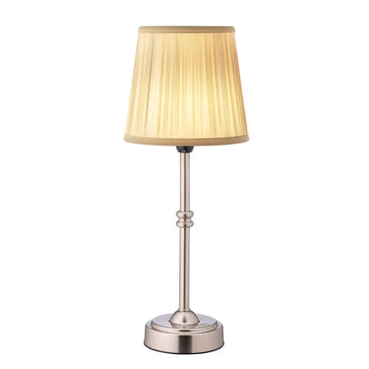 Cordless LED table lamp with fabric shade on a shelf in an apartment