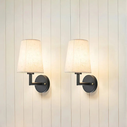 Wireless fabric wall sconce with metal accents, mounted on a wall, for renters