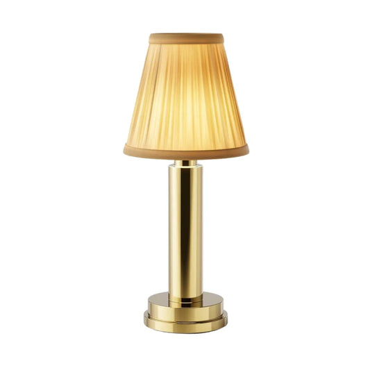Cordless brass table lamp with fabric shade on a wooden table, portable for home decor