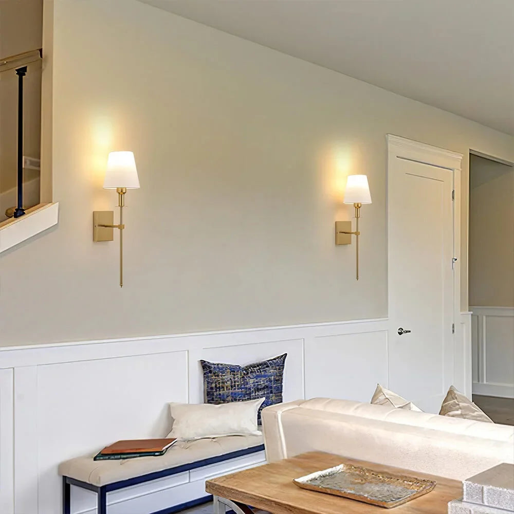 Rechargeable wireless wall light with metal accents, mounted on a wall in a living room, for renters