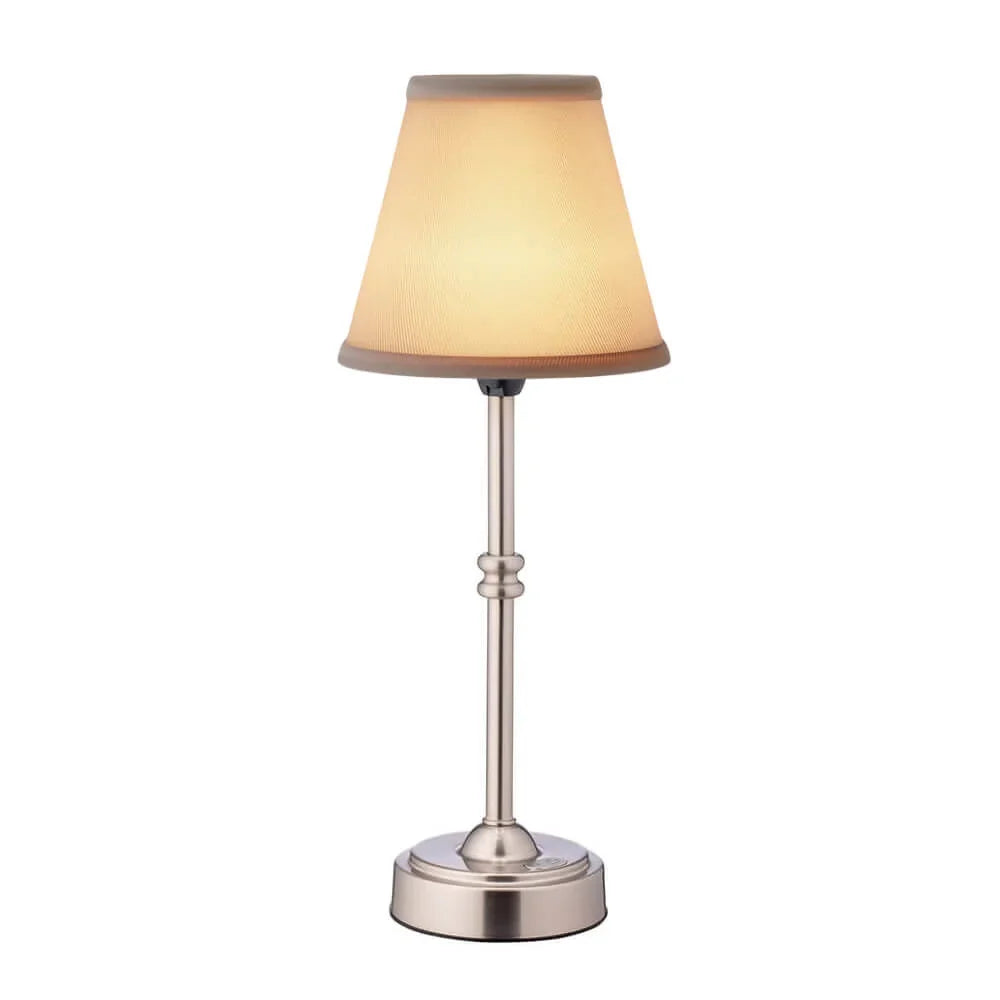 Cordless LED table lamp with fabric shade on a shelf in an apartment