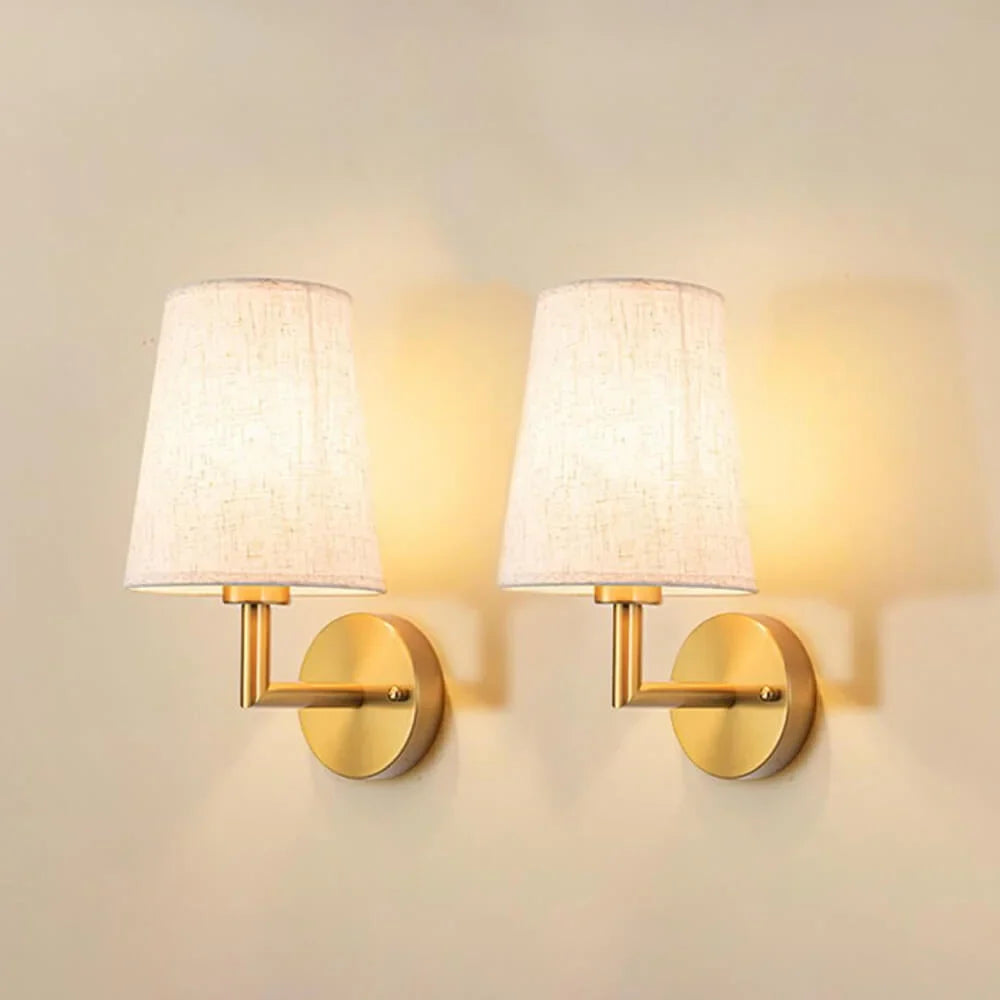 Wireless fabric wall sconce with metal accents, mounted on a wall, for renters