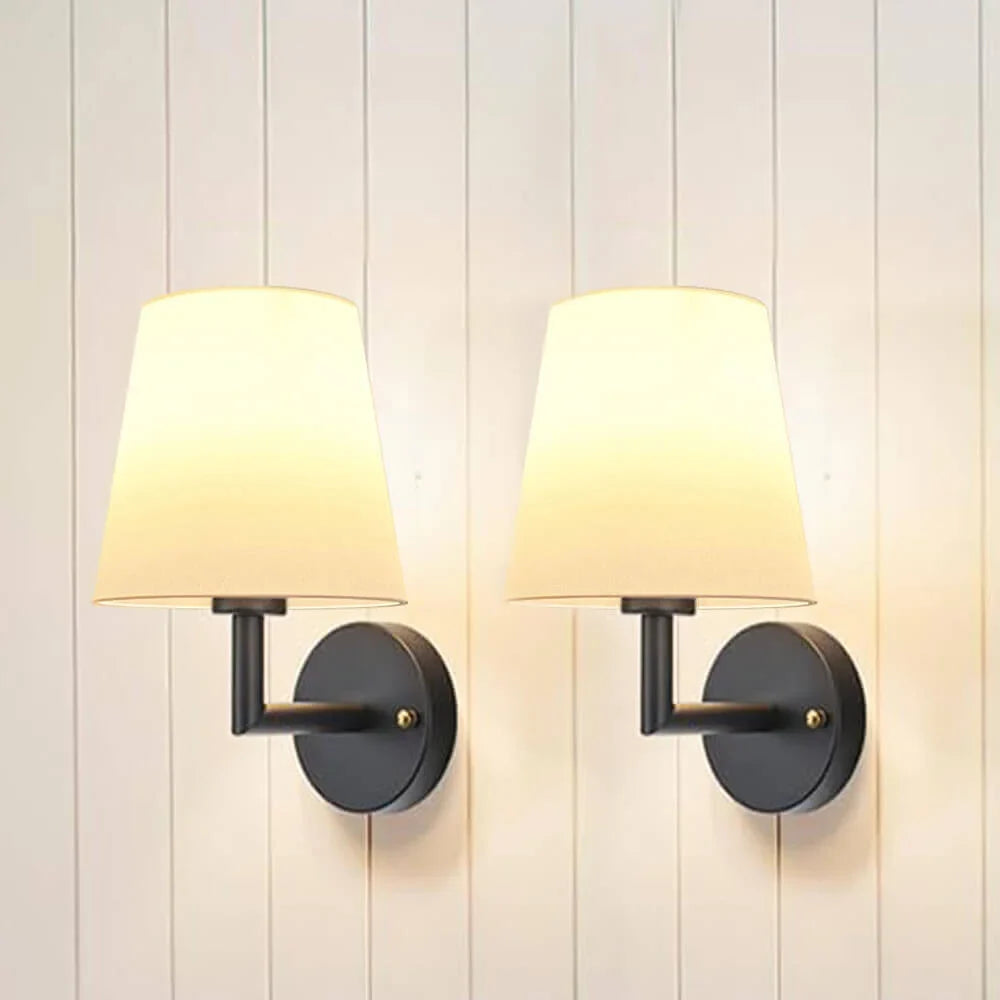 Wireless fabric wall sconce with metal accents, mounted on a wall, for renters