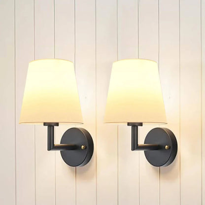 Wireless fabric wall sconce with metal accents, mounted on a wall, for renters
