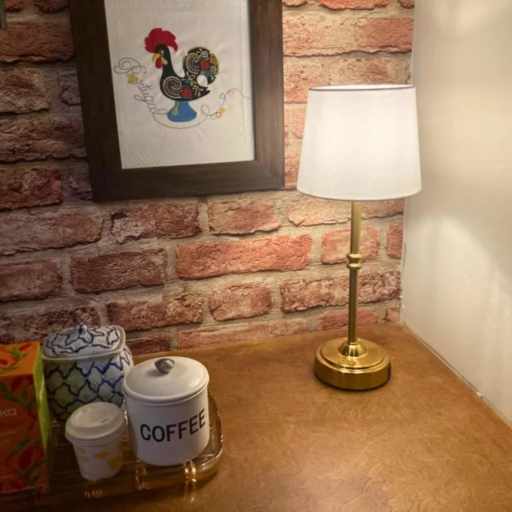 Cordless LED table lamp with fabric shade on a shelf in an apartment