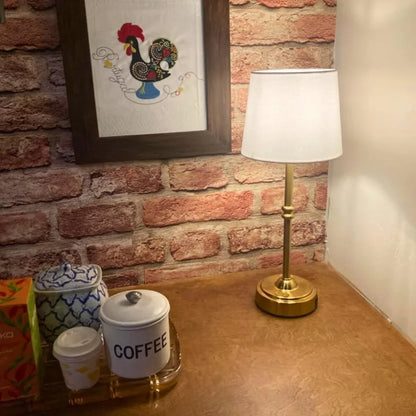 Cordless LED table lamp with fabric shade on a shelf in an apartment