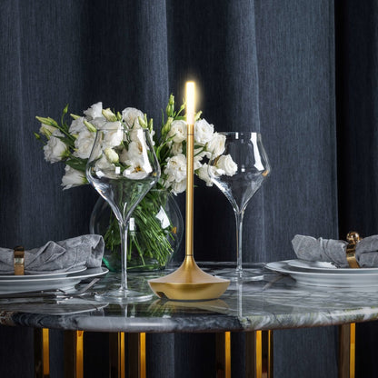 Rechargeable portable LED candle lamp with warm amber glow on a table, suitable for indoor and outdoor ambiance