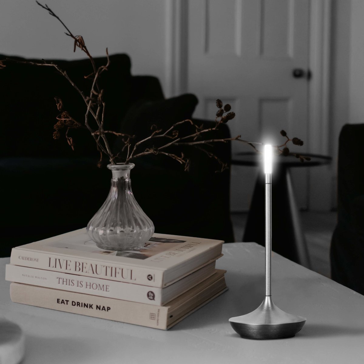 Rechargeable portable LED candle lamp with warm amber glow on a table, suitable for indoor and outdoor ambiance