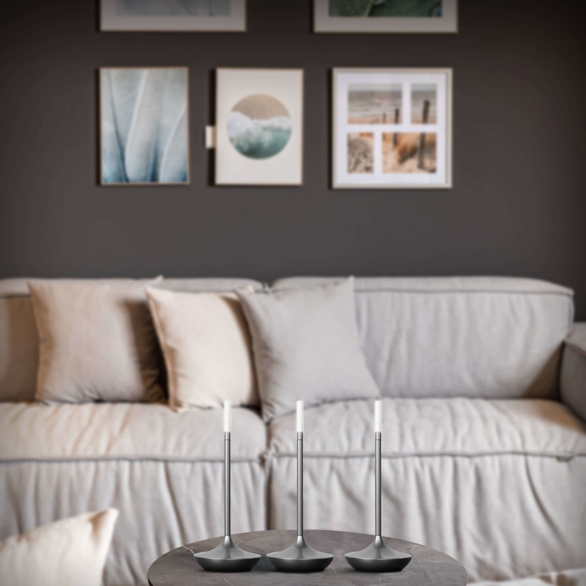 Rechargeable LED candle lamp with brass finish and carrying ring, glowing warmly on a table