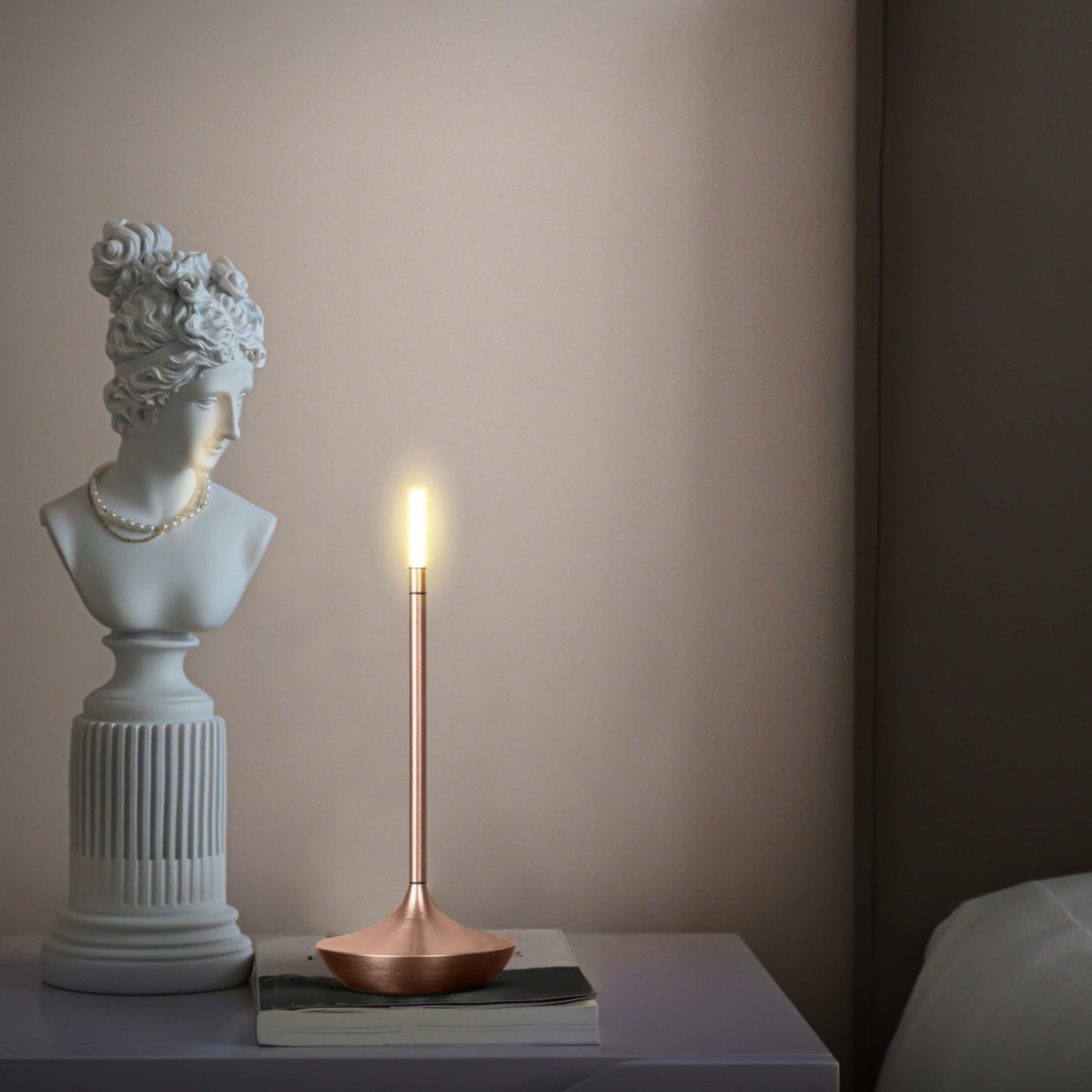 Rechargeable portable LED candle lamp with warm amber glow on a table, suitable for indoor and outdoor ambiance