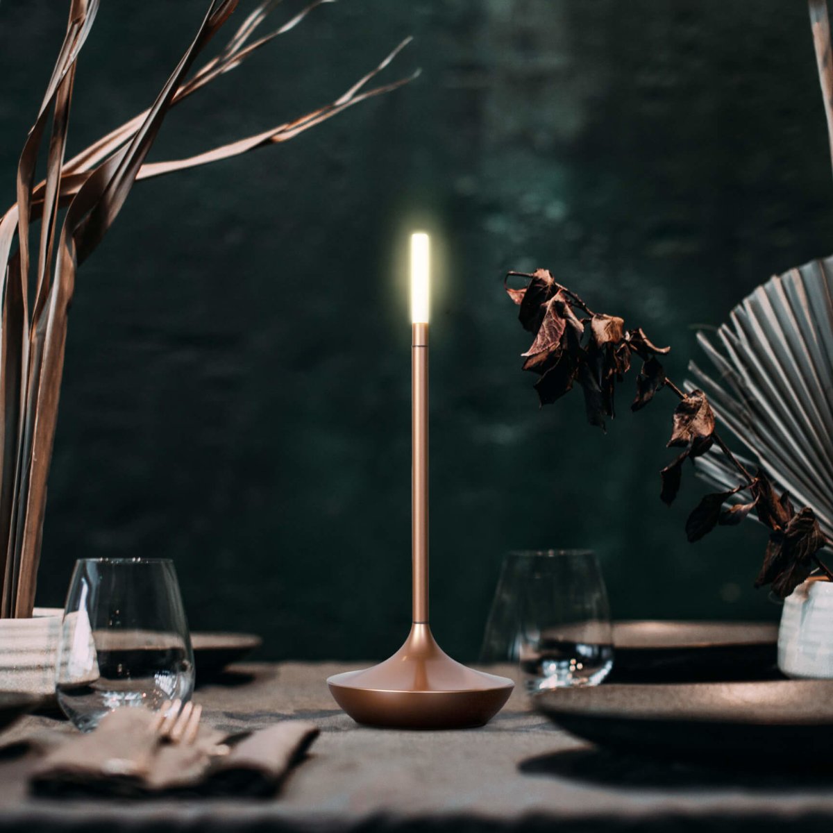 Rechargeable portable LED candle lamp with warm amber glow on a table, suitable for indoor and outdoor ambiance