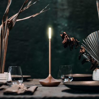 Rechargeable portable LED candle lamp with warm amber glow on a table, suitable for indoor and outdoor ambiance