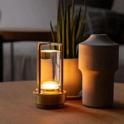 Cordless table lamp with metal cage and warm glow on a camping table