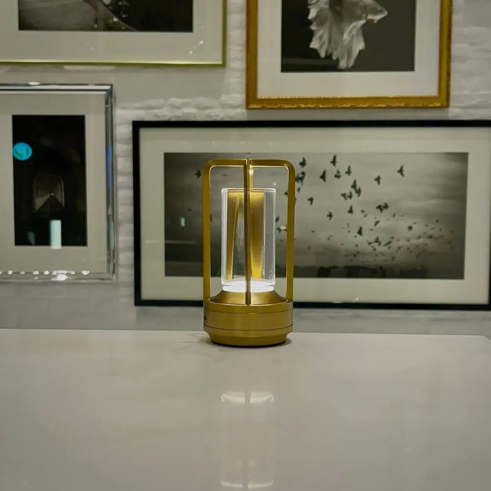 Cordless table lamp with metal cage and warm glow on a camping table