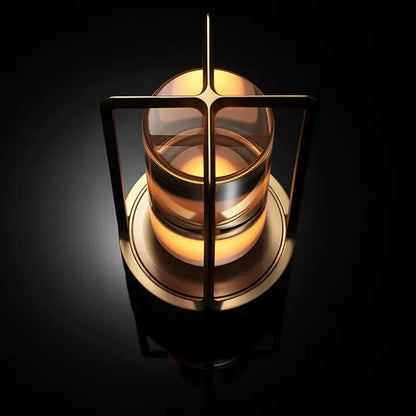 Cordless table lamp with metal cage and warm glow on a camping table