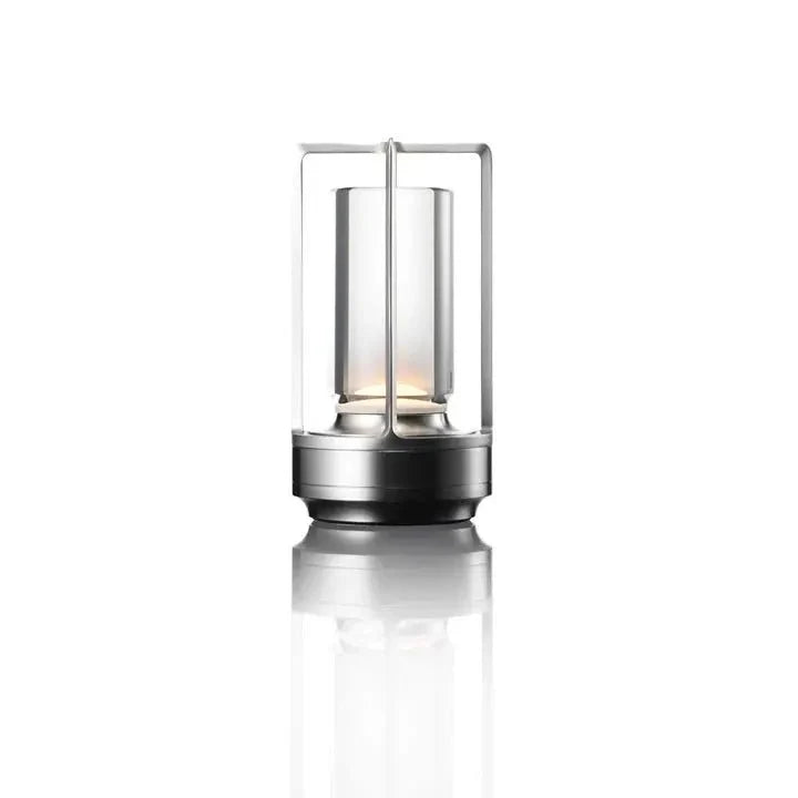 Cordless table lamp with metal cage and warm glow on a camping table